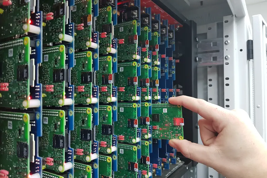 A technician sliding a Raspberry Pi into a rack slot